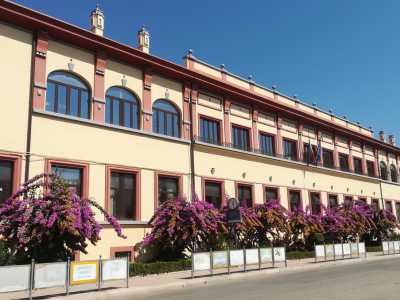 L�edificio richiama comunque alcuni dei canoni classici del Ventennio, come la ripartizione quasi militare della sua parte laterale. Quest�ultima si presenta con un prospetto allungato le cui linee di fuga risultano raddoppiate grazie al doppio ordine delle finestre